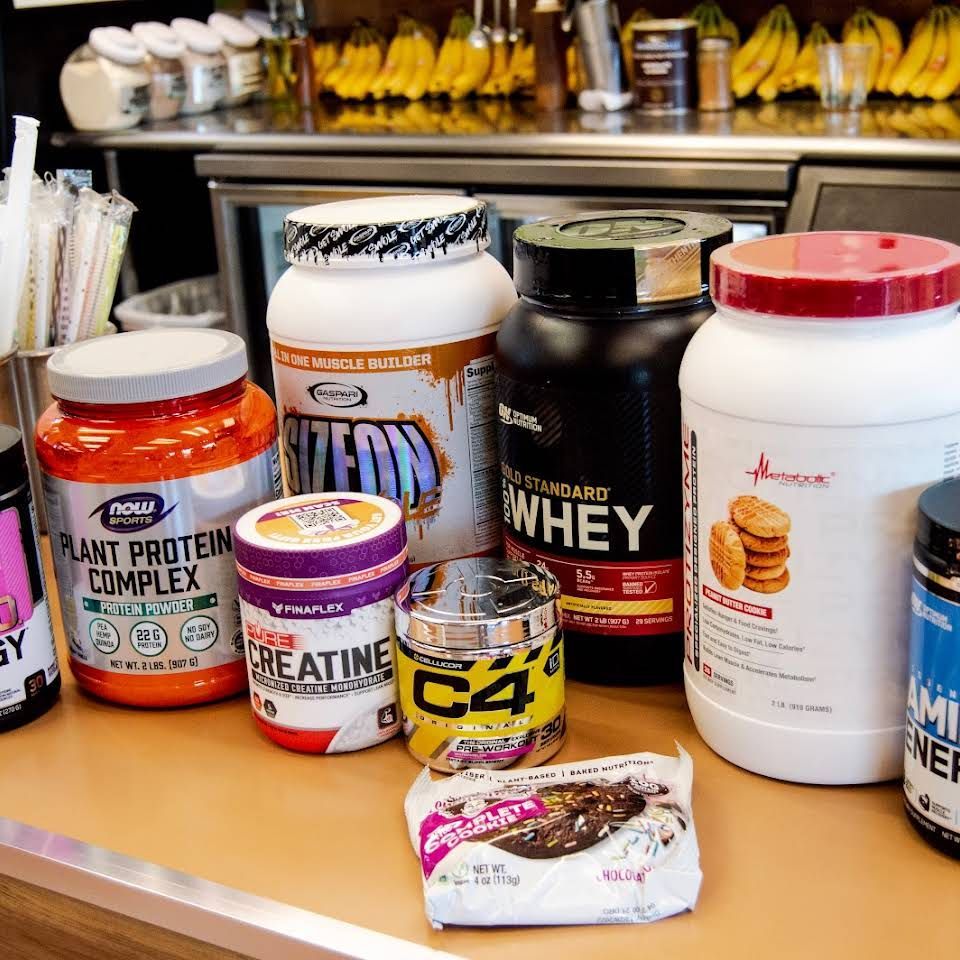 A variety of protein powders are sitting on a counter