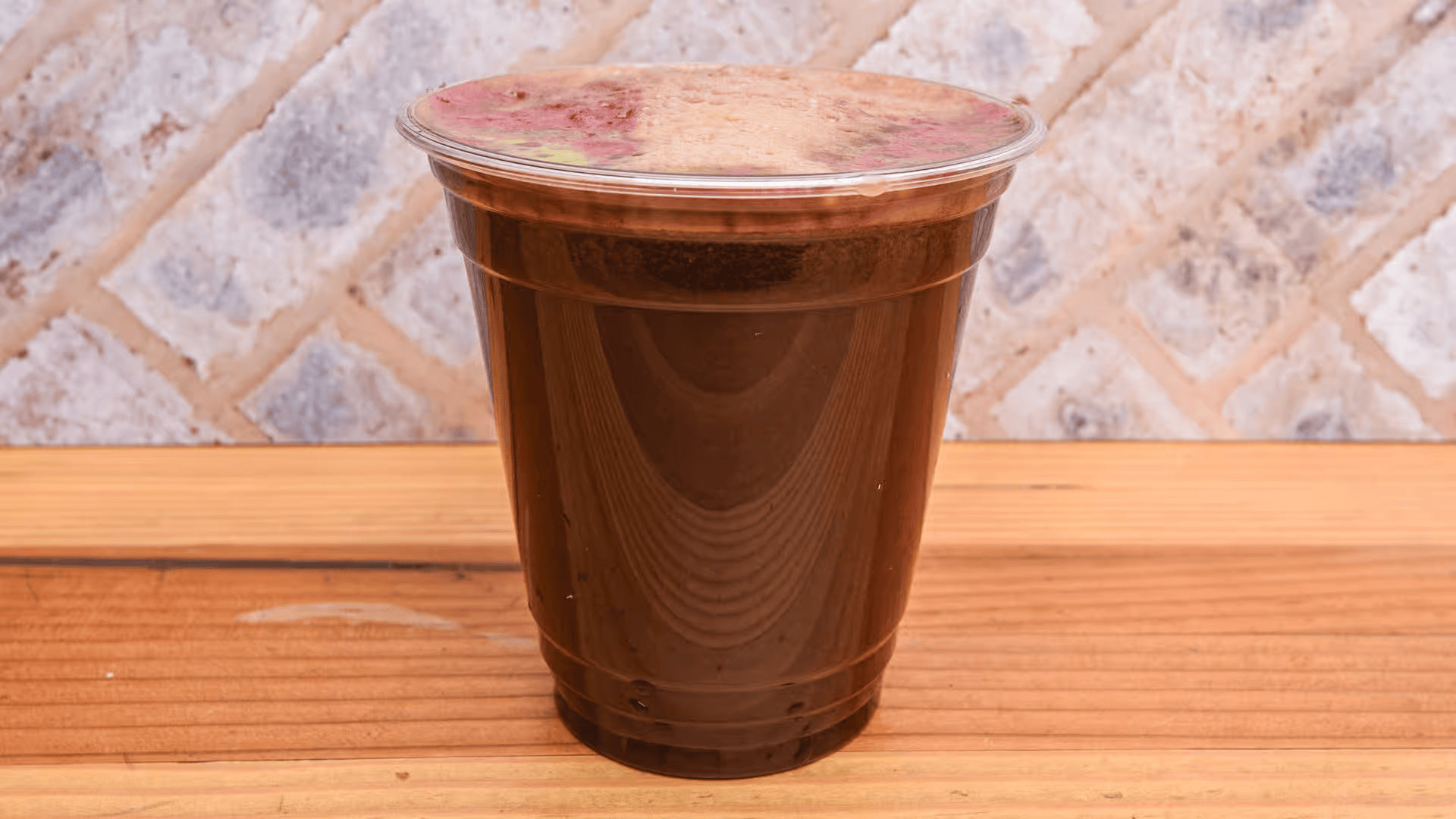 A cup of coffee is sitting on a wooden table.