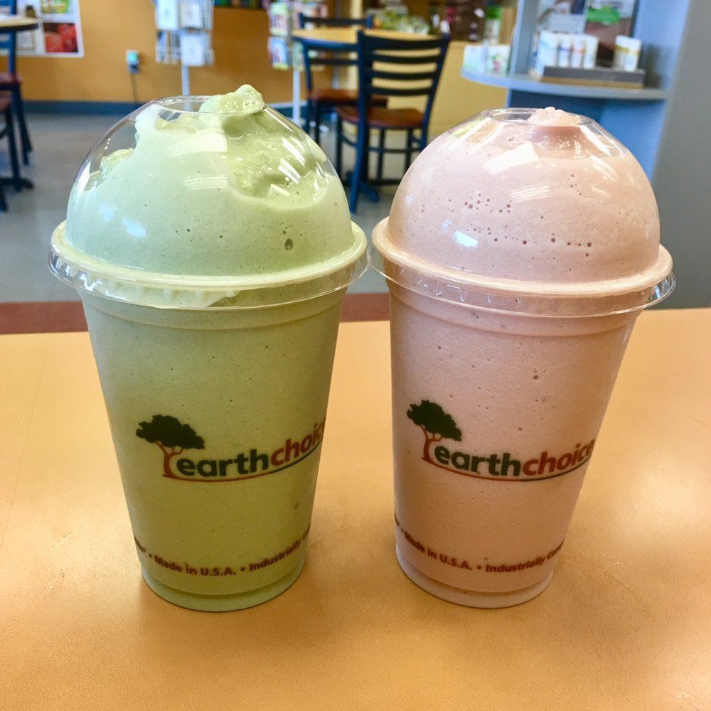 A green and a pink smoothie from earth chock are on a table