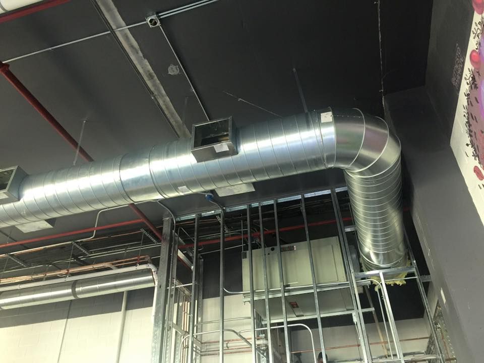 A large metal pipe is hanging from the ceiling of a building.