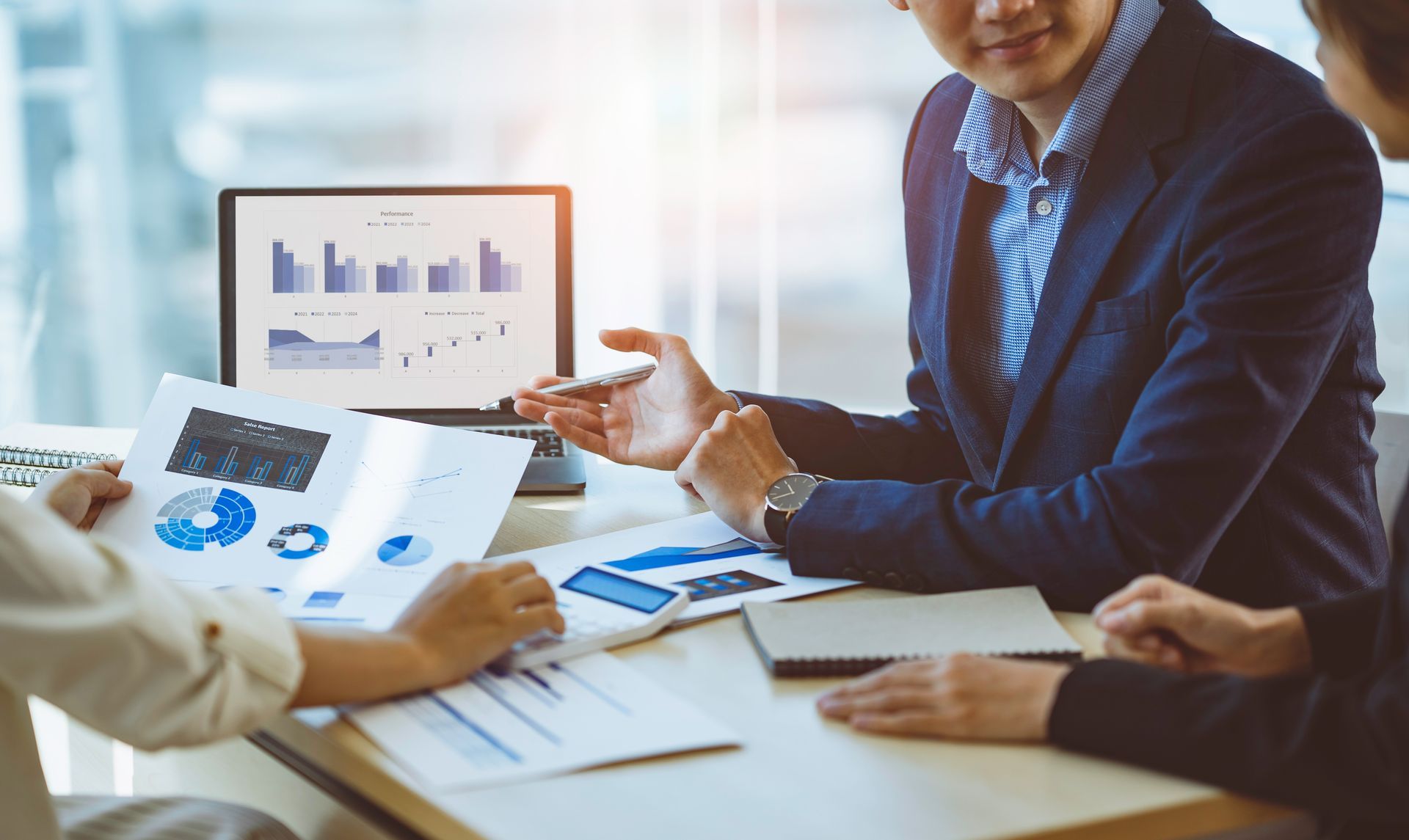 Business tax consultant services meeting with clients reviewing financial charts and reports.