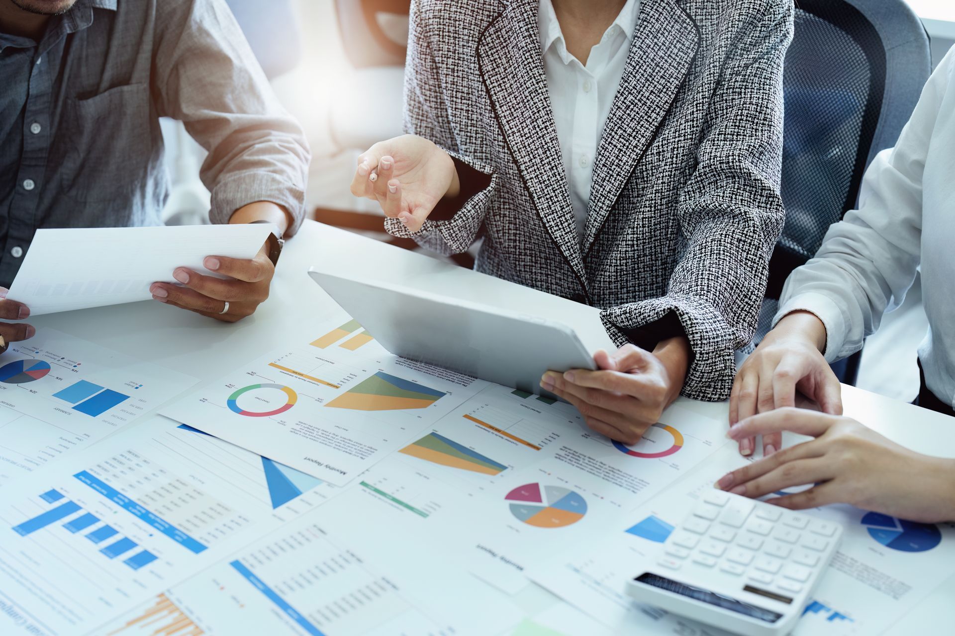 Tax consultants reviewing financial reports and calculations at the table.