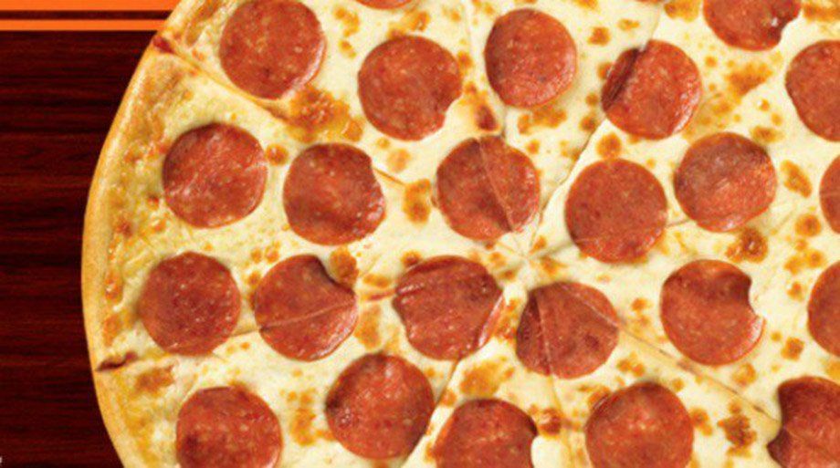 Close-up of a pepperoni pizza cut into triangular slices. Pepperoni is red-orange against a backdrop of melted cheese on golden crust.