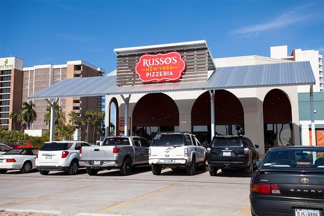 Russo's Pizza restaurant with cars parked out front on a sunny day.