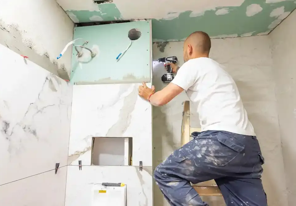 A plumber is fixing a pipe with a wrench.