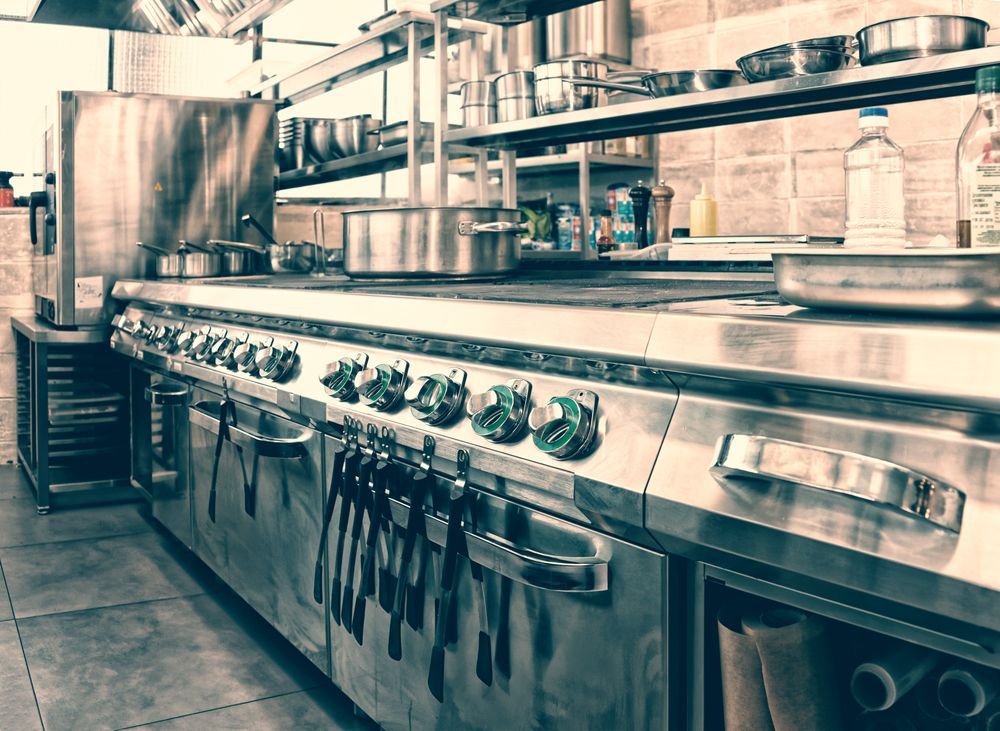 Commercial kitchen with stainless steel stove, pots, and shelves — Townsville Stainless Steel in Garbutt, QLD