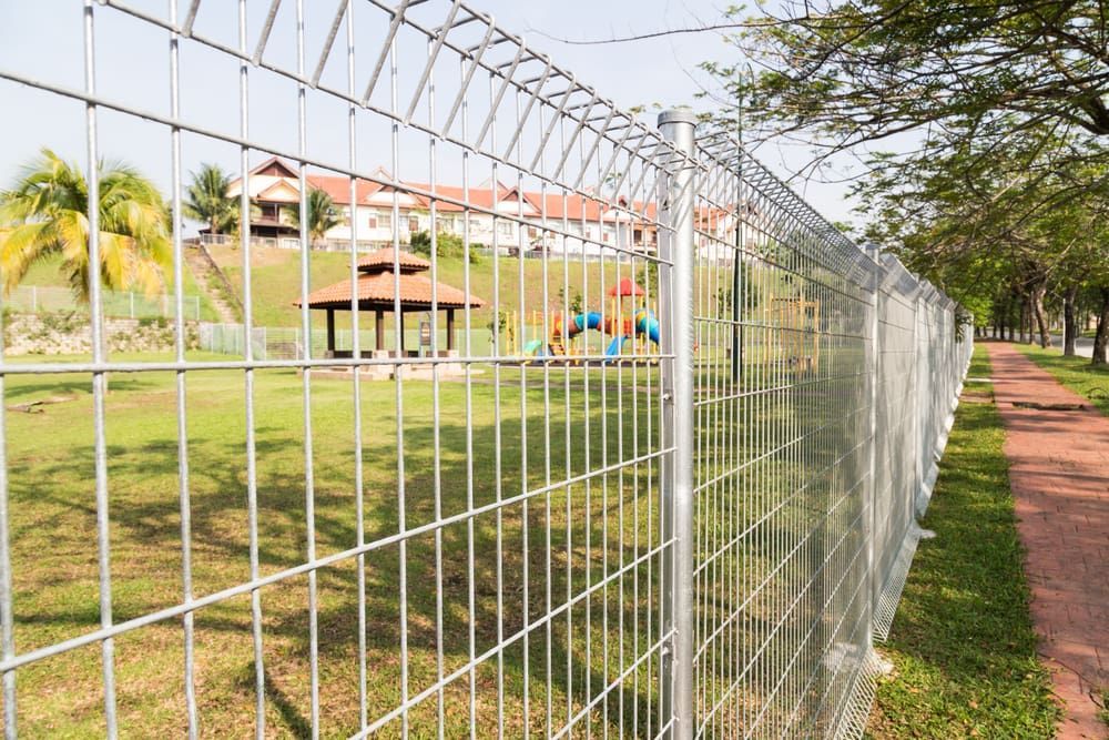 A Metal Wire Fence Lines a Grassy Area — Townsville Stainless Steel in Cooktown, QLD