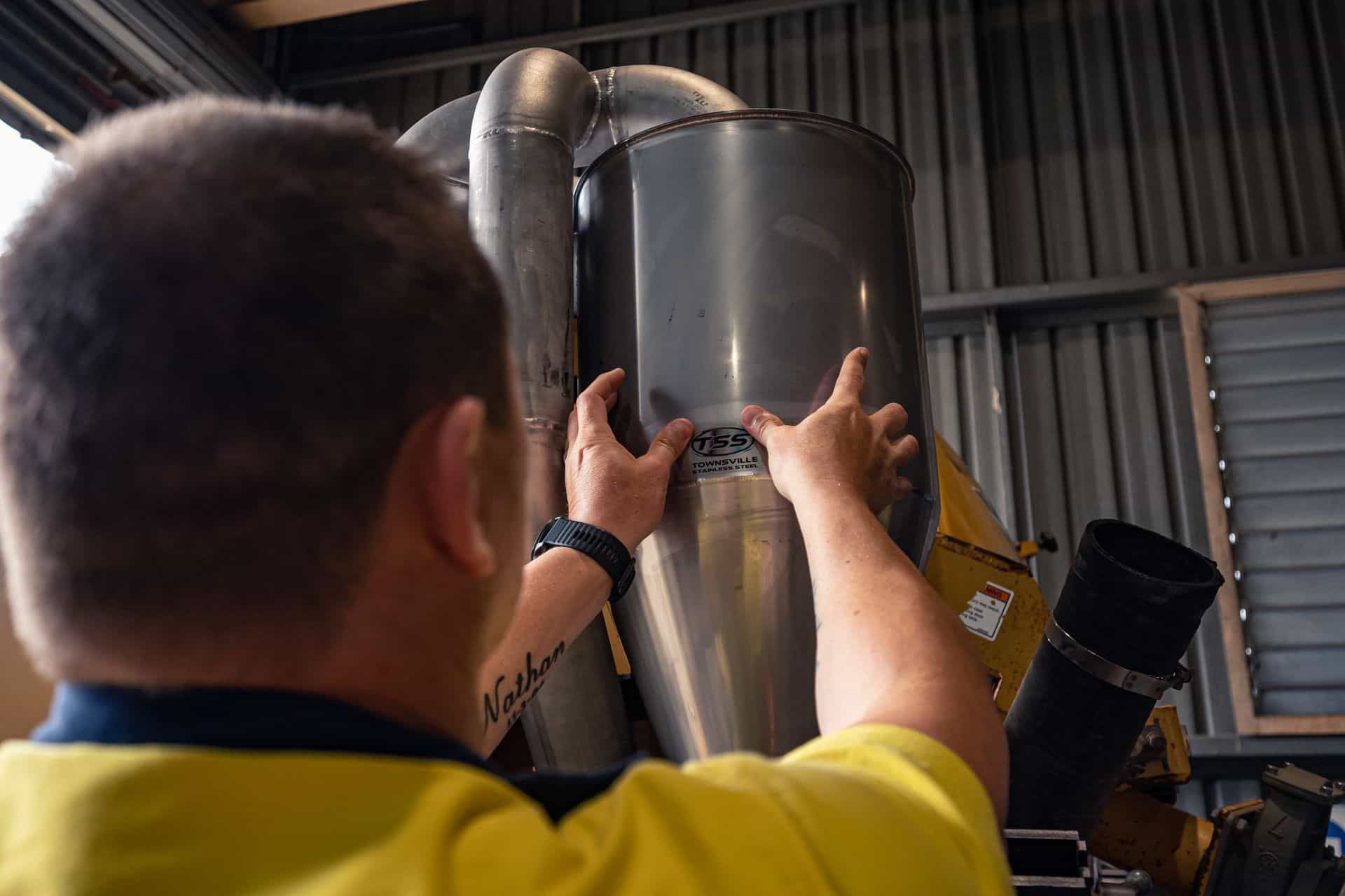 Man in Yellow Shirt Working on a Large Metal Cylinder — Townsville Stainless Steel in Garbutt, QLD