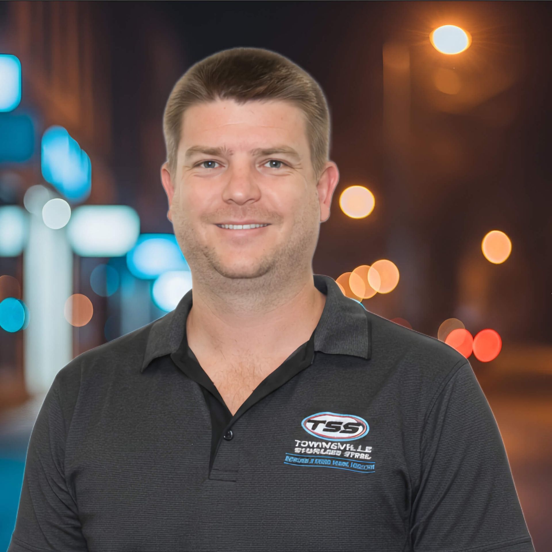 Man with short brown hair, smiling, wearing a black polo with logo, outdoors at night - Townsville Stainless Steel in Garbutt, QLD