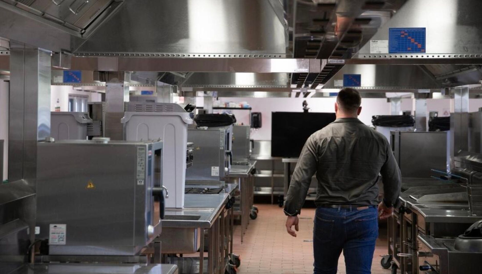 A Man is Walking Through a Kitchen Filled — Townsville Stainless Steel in Garbutt, QLD