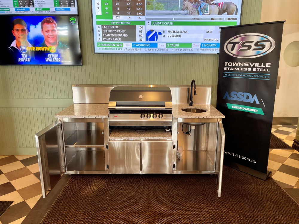 Stainless steel outdoor kitchen with grill and sink; TV screens with horse race background.— Townsville Stainless Steel in Garbutt, QLD