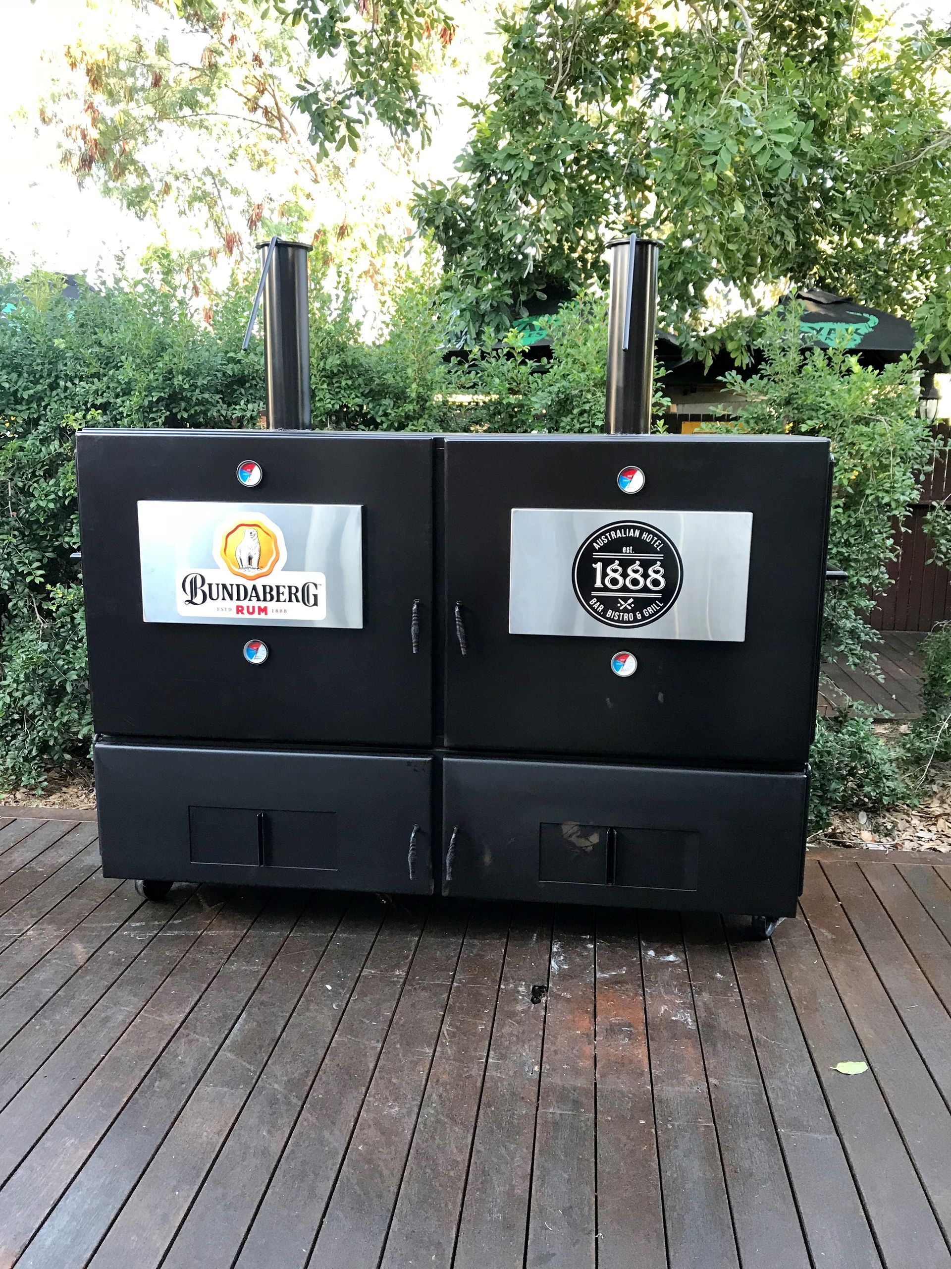 A Barbecue Grill with Smoke Coming out Of It and A Piece of Meat on A Plate — Townsville Stainless Steel in Garbutt, QLD