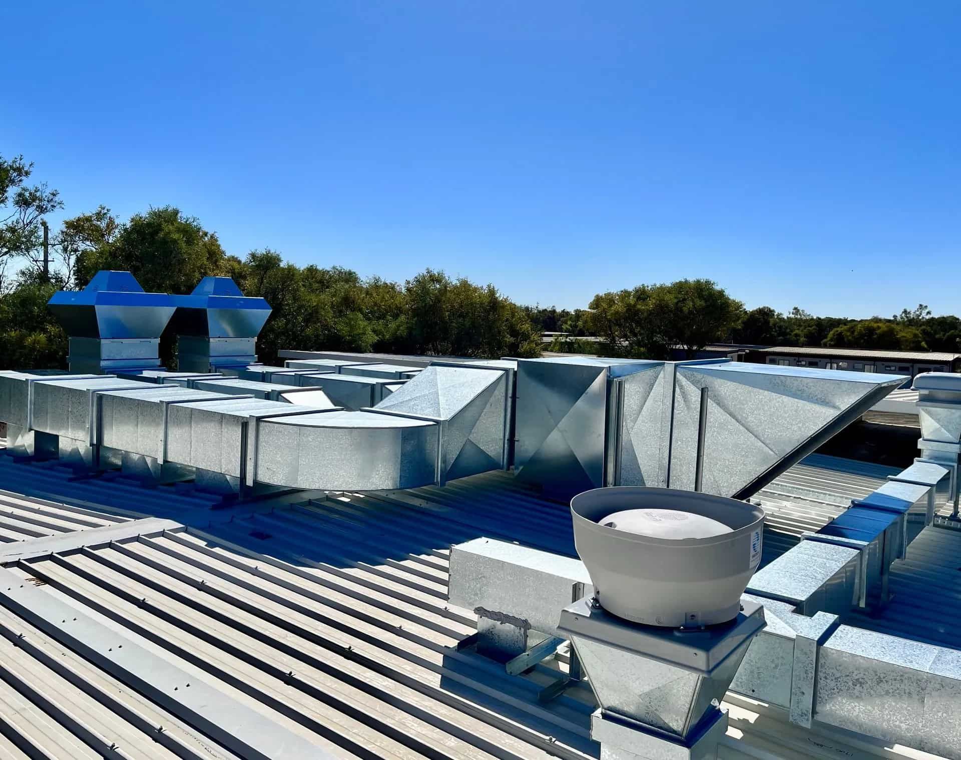 Galvanized Metal Hvac Ductwork and Vents on a Rooftop Under a Clear Blue Sky — Townsville Stainless Steel in Garbutt, QLD