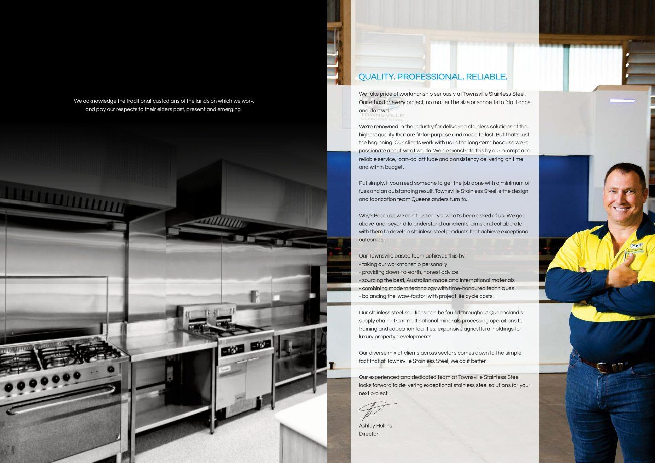 A Man in A Yellow Vest Is Standing in Front of A Kitchen with Stainless Steel Appliances — Townsville Stainless Steel in Garbutt, QLD