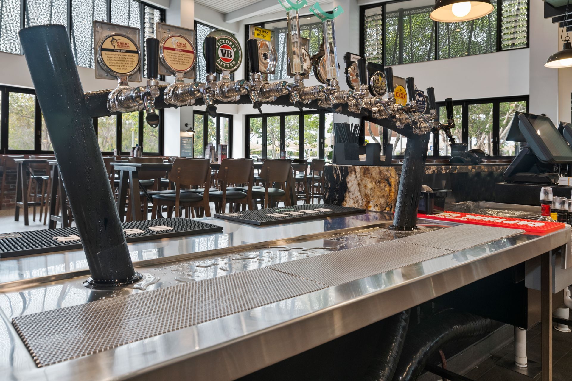 Bar with beer taps, stainless steel countertop, and tables in background — Townsville Stainless Steel in Garbutt, QLD