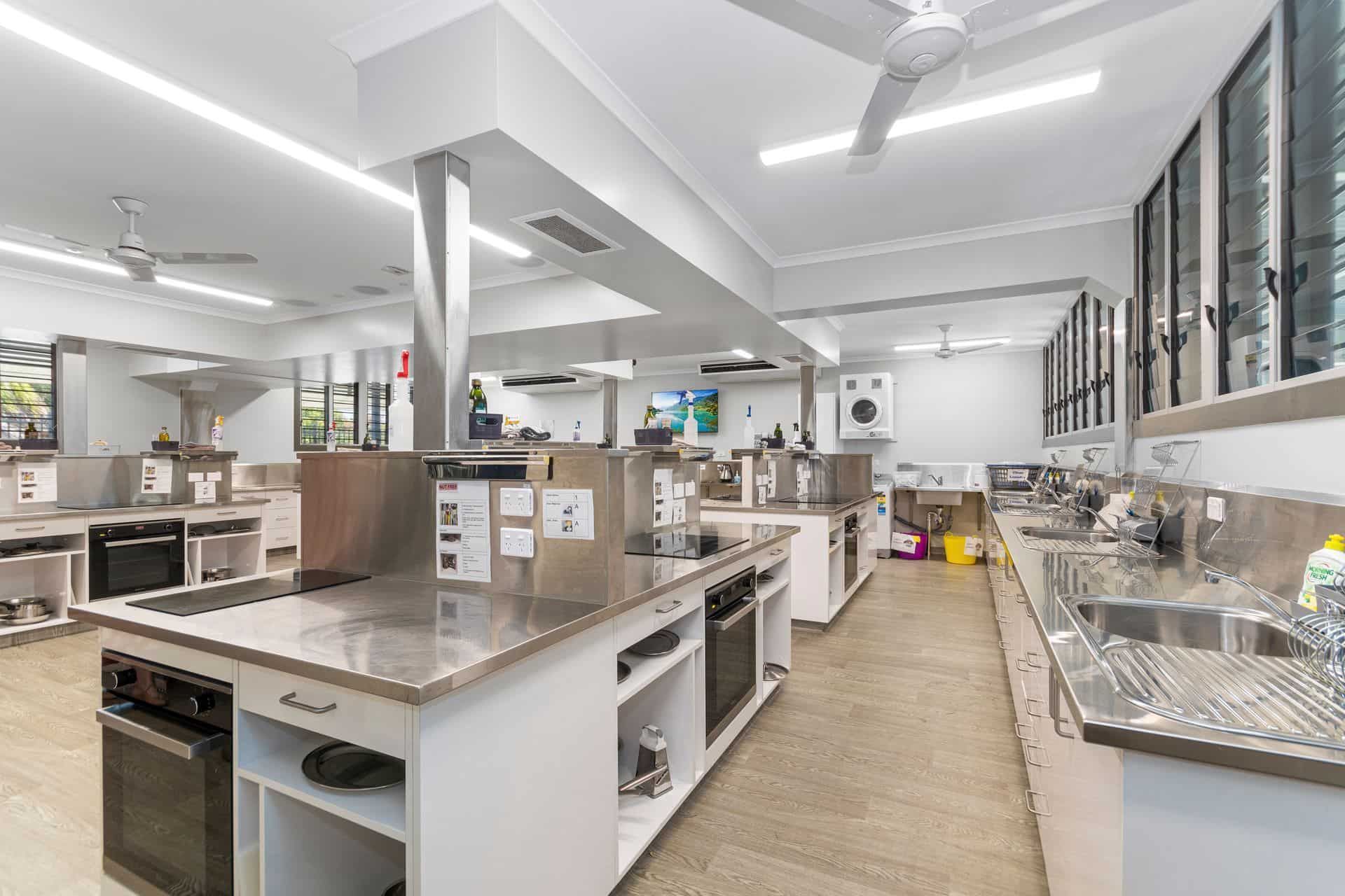 Bright Kitchen Classroom With Stainless Steel Workstations and Ovens — Townsville Stainless Steel in Garbutt, QLD