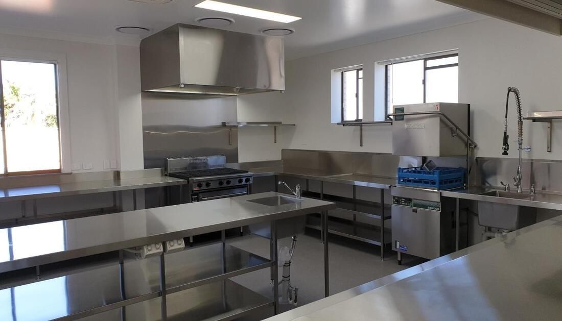 A Large Kitchen with Stainless Steel Counter Tops and Appliances — Townsville Stainless Steel in Weipa, QLD