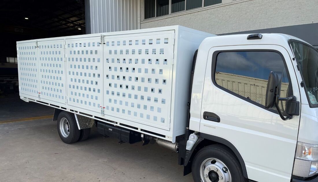A White Truck with A Cage on The Side Is Parked in Front of A Building — Townsville Stainless Steel in Garbutt, QLD