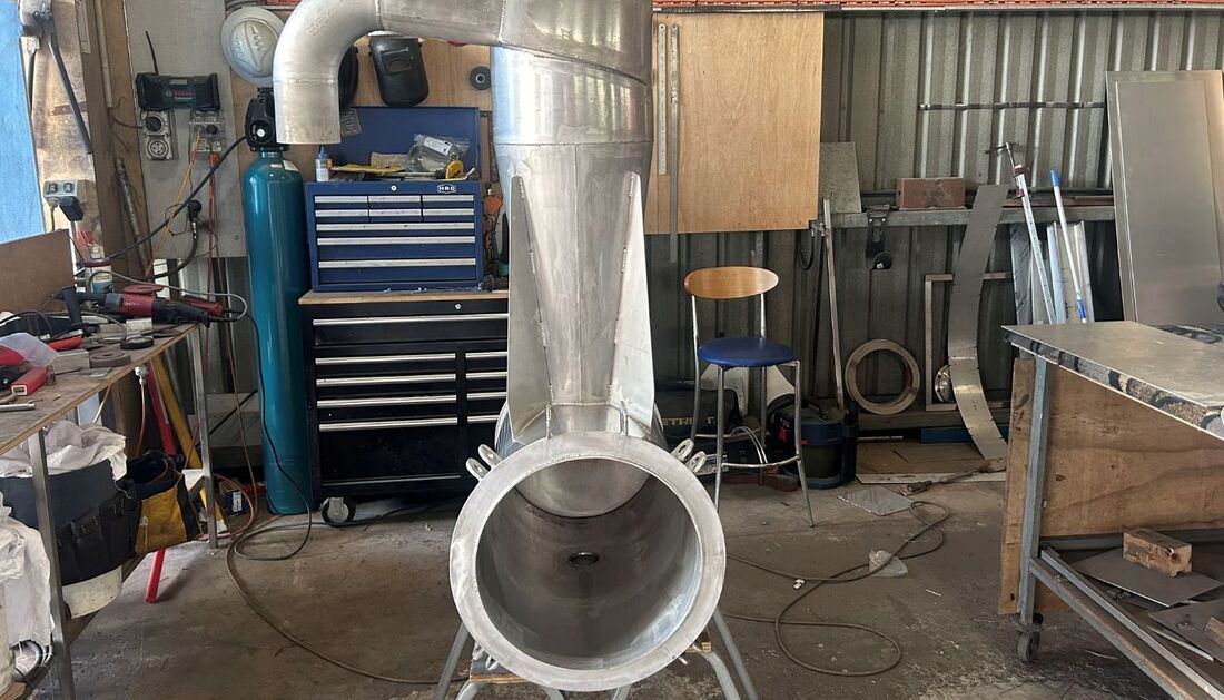 A Large Pipe Is Sitting in A Workshop Next to A Chair — Townsville Stainless Steel in Garbutt, QLD
