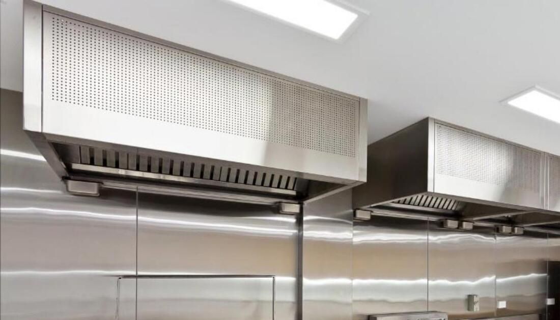 Two Stainless Steel Hoods Are Hanging from The Ceiling in A Kitchen — Townsville Stainless Steel in Garbutt, QLD