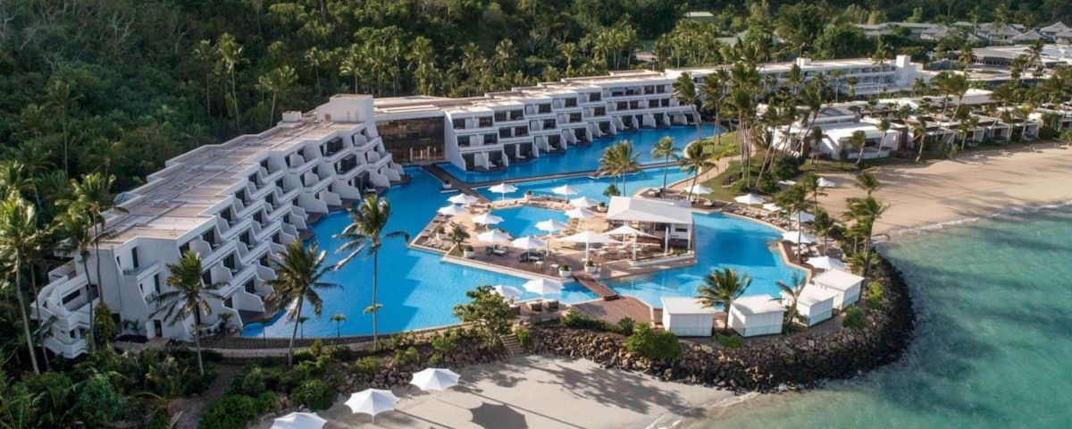 An Aerial View of A Hotel Surrounded by Palm Trees and Umbrellas  — Townsville Stainless Steel in Garbutt, QLD