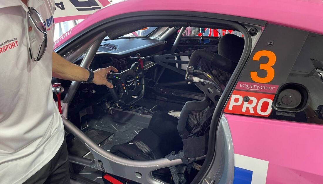 A Man Is Standing Next to A Pink Race Car with The Number 3 on The Side  — Townsville Stainless Steel in Garbutt, QLD