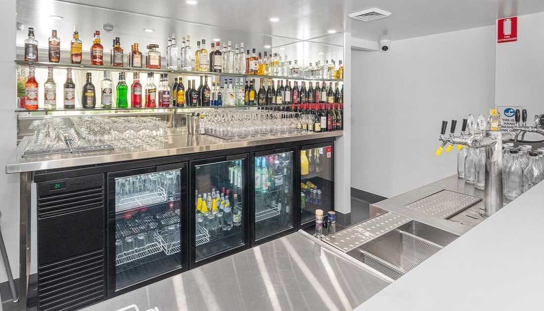 A Bar with A Lot of Bottles on The Shelves and A Sink — Townsville Stainless Steel in Garbutt, QLD