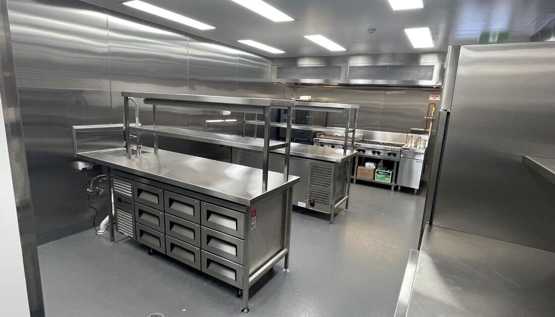 A Large Kitchen with Stainless Steel Appliances and Shelves  — Townsville Stainless Steel in Garbutt, QLD