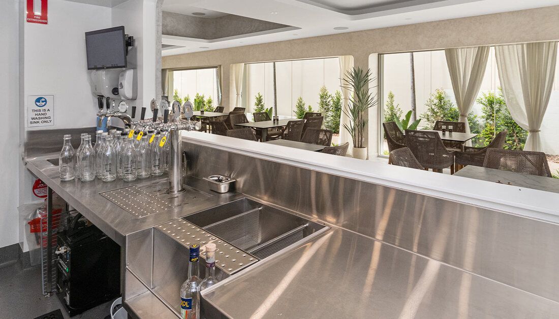 A Stainless Steel Bar in A Restaurant with A Lot of Bottles on It — Townsville Stainless Steel in Garbutt, QLD