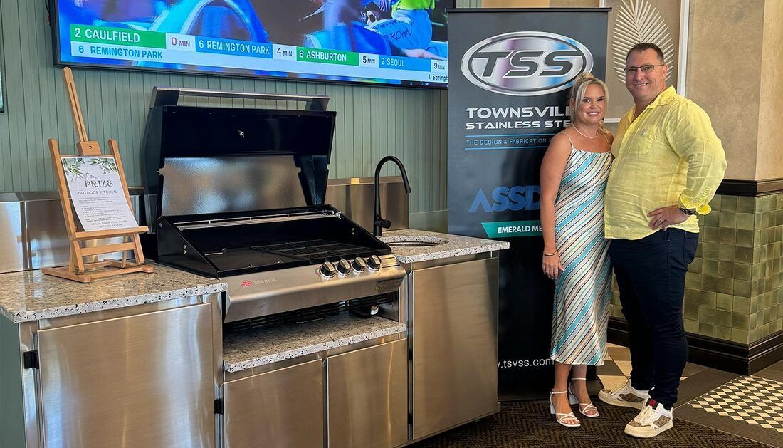 A Man and A Woman Are Standing in Front of A Grill — Townsville Stainless Steel in Garbutt, QLD