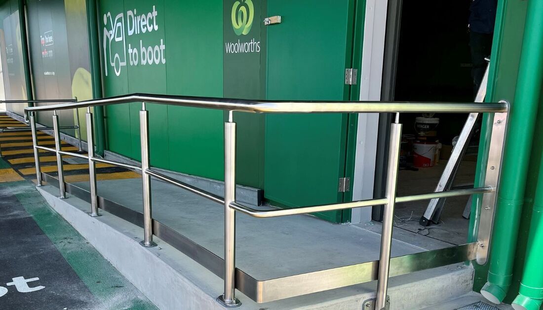 A Ramp with A Stainless Steel Railing Leading to A Green Door  — Townsville Stainless Steel in Garbutt, QLD