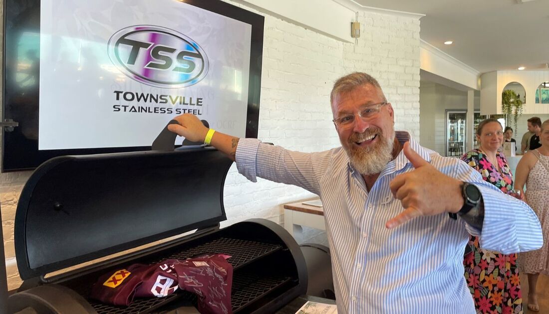 A Man Is Standing in Front of A Grill and Giving a Thumbs Up — Townsville Stainless Steel in Garbutt, QLD