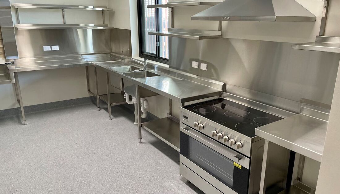 A Kitchen with Stainless Steel Appliances and A Stove — Townsville Stainless Steel in Garbutt, QLD