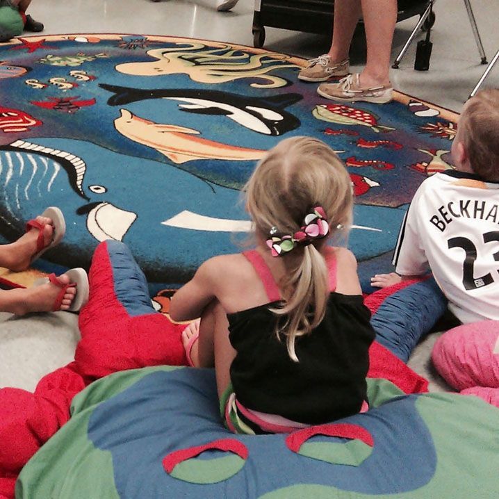 A girl wearing a beckham 23 jersey sits on the floor
