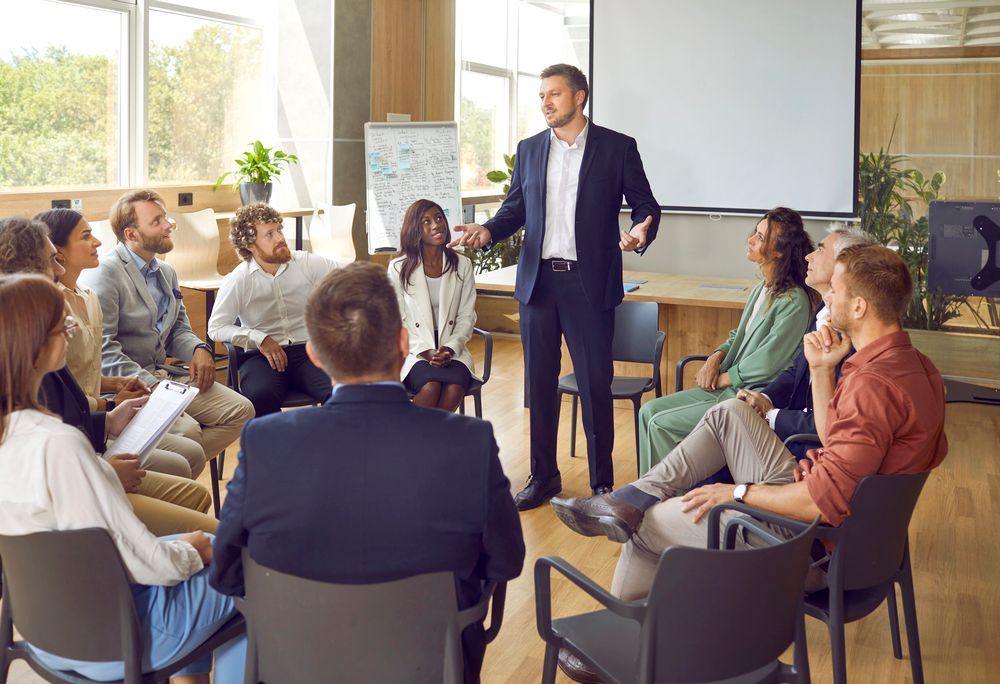 Un grupo de personas está sentado en círculo en una oficina luminosa