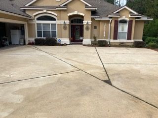 A large house with a concrete driveway in front of it.