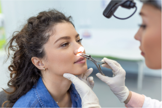 A woman is getting her nose examined by a doctor.