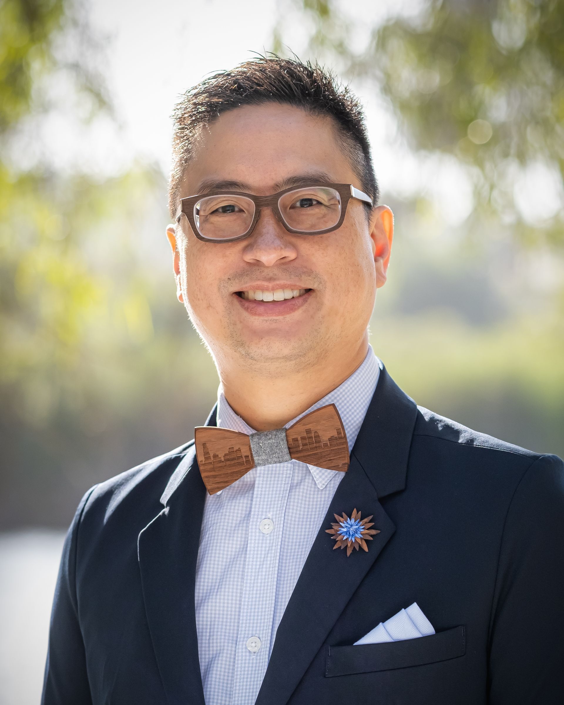 Dr. Gene Liu in a suit and bow tie is smiling for the camera.