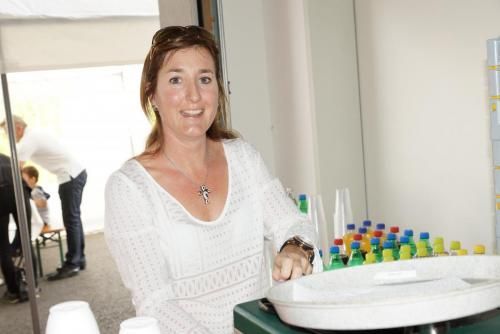 Eine Frau in einem weißen Hemd steht vor einer Theke.