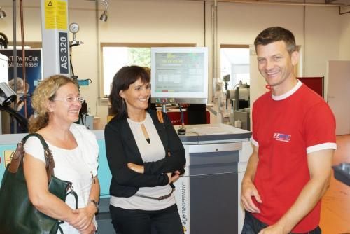 Ein Mann in einem roten Hemd spricht mit zwei Frauen