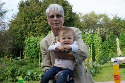 Eine ältere Frau hält ein Baby in ihren Armen.