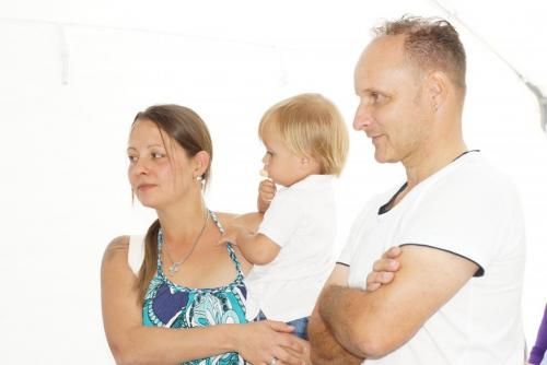 Ein Mann und eine Frau halten ein Baby in ihren Armen.