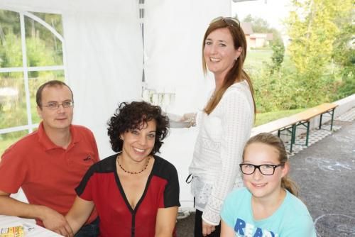 Eine Gruppe von Menschen posiert in einem Zelt für ein Foto.