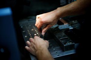 Eine Nahaufnahme der Hände einer Person, die an einer Maschine arbeitet.