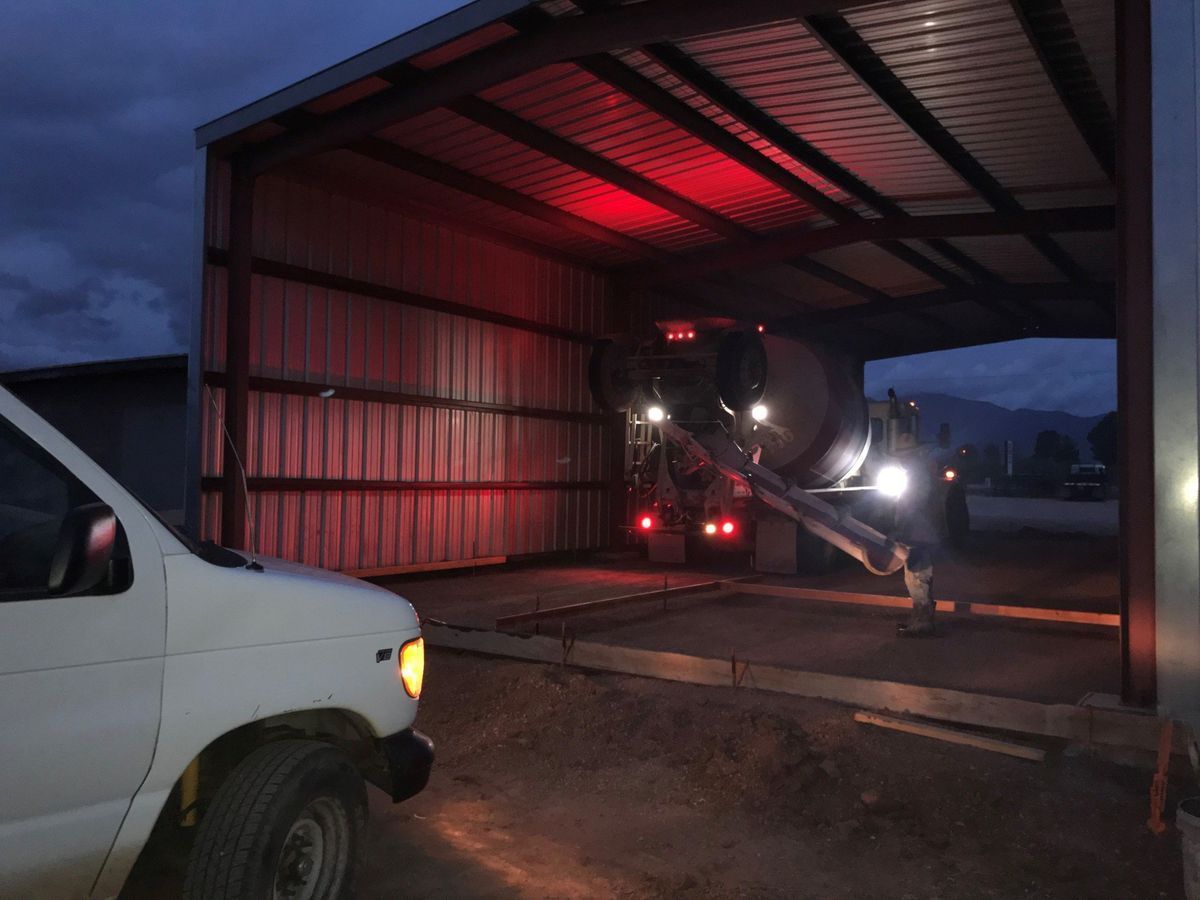 A white van is parked in front of a building with a red light on the roof