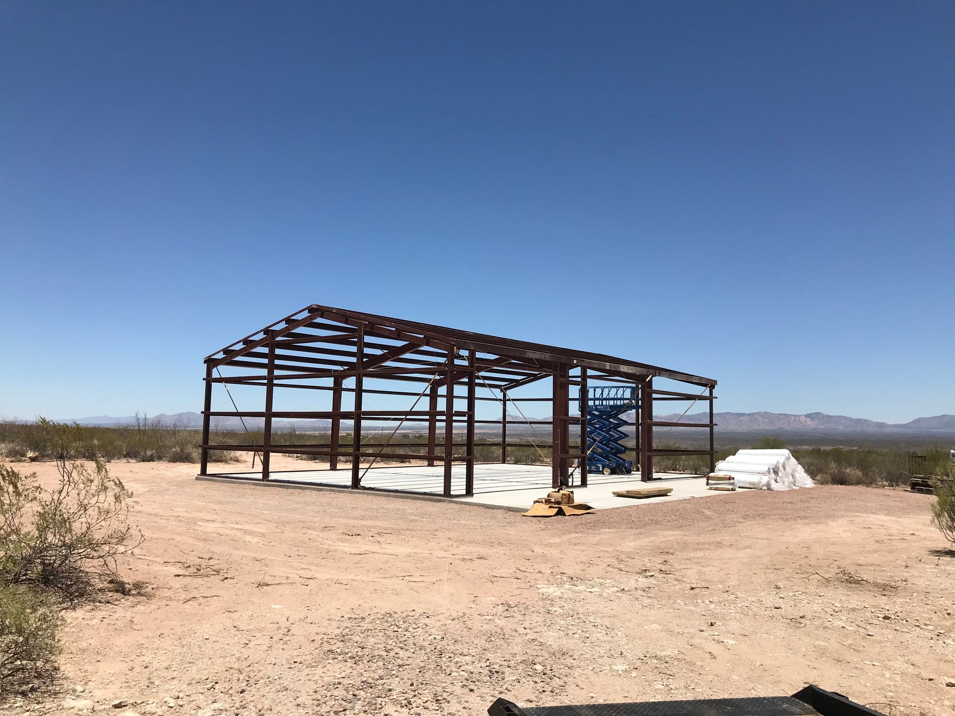 A large metal structure is being built in the middle of a desert.
