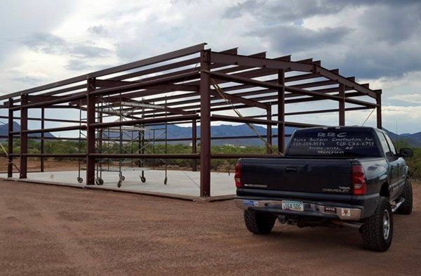 A truck is parked in front of a building under construction.