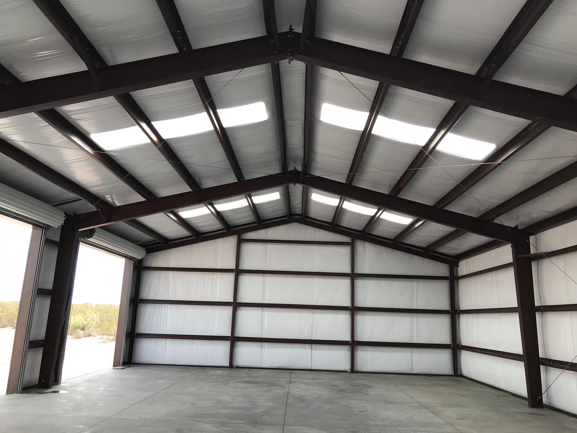 A large warehouse with a metal roof and white walls.