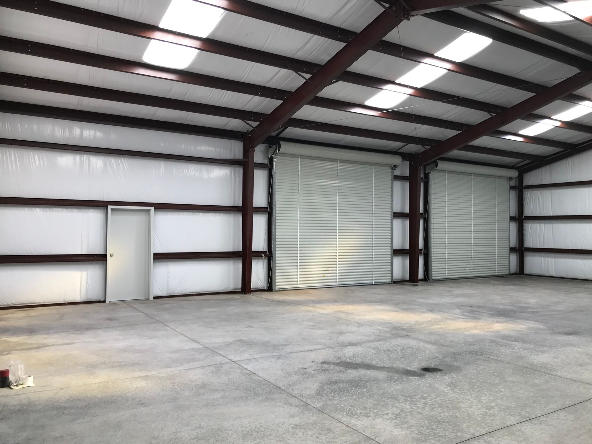 A large empty warehouse with a concrete floor and a door.
