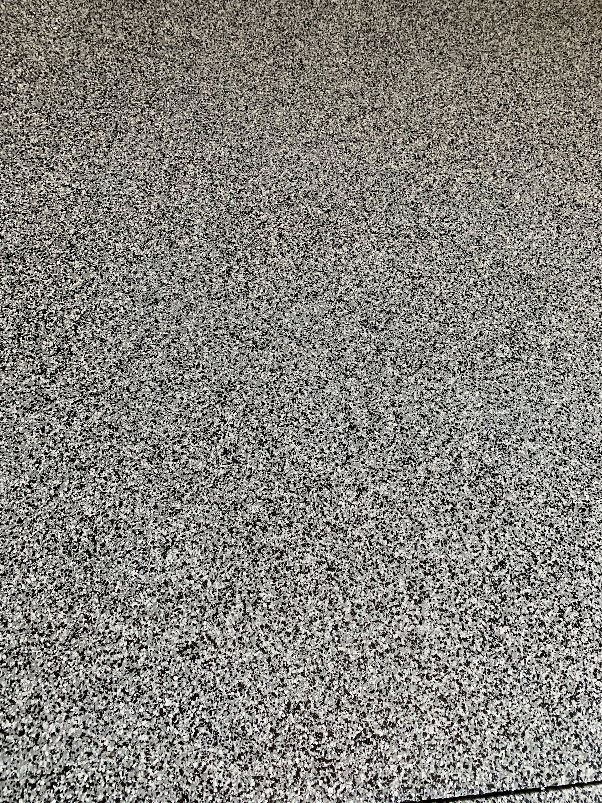 A close up of a gray carpet with a lot of small stones on it.
